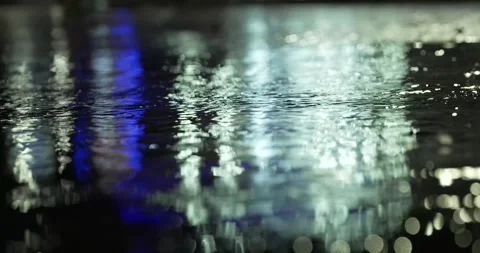 Rain falling on paving dancing with light at night low angle Stock Footage 277388137