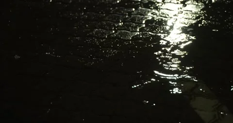 Rain falling on paving dancing with light Stock Footage 277388206