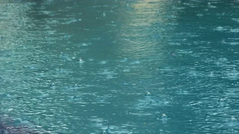 Rain falling into the pool filmed in Vídeos de archivo 169322320
