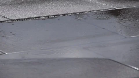 Rain falling on a puddle with the reflection of cars passing by Stock Footage 196209803