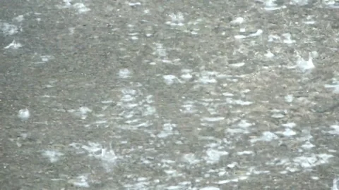 Rain falling on the road creating a water ripple Stock Footage 294673067