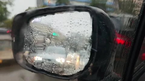 Rain falling on side mirror reflecting traffic 库存影片 315361207