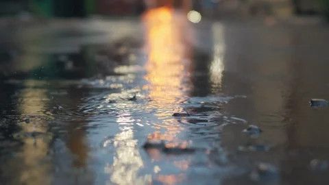Rain falling in slow motion on city street at night. Stock Footage