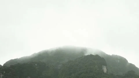 Rain Falling with slowly moving white cloud and mist on sky over mountain Stock Footage 153506309