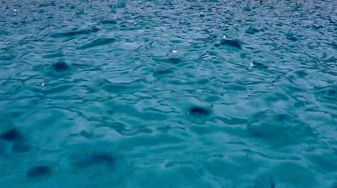 Rain falling into a swimming pool during a thunderstorm in slow motion Видео 63900021