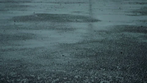 Rain Falling on Tarmac with Wet Reflections, Tilt from Distance to Close Up Stock Footage 330726865