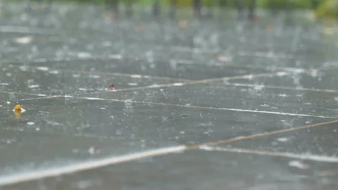 Rain falling on tile outside close up rack focus Stock Footage 120303394