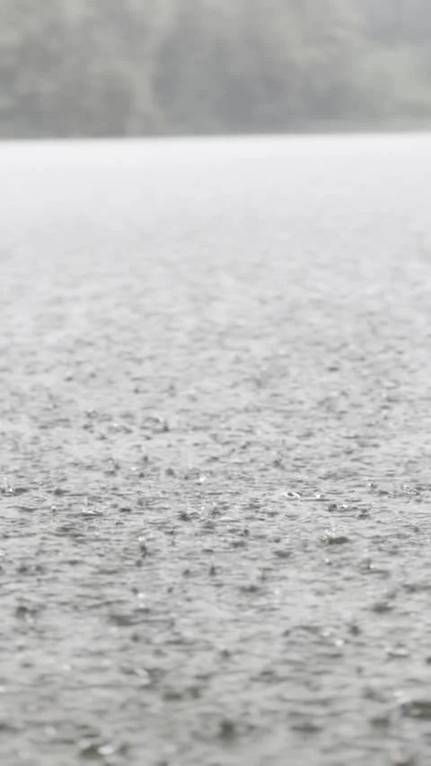 Rain falling on water surface during storm Stock Footage 330752997