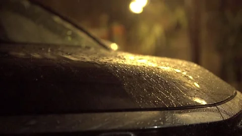 Rain Falling on Wet Car Hood at Night Under Warm Street Lights Stock Footage 345274376