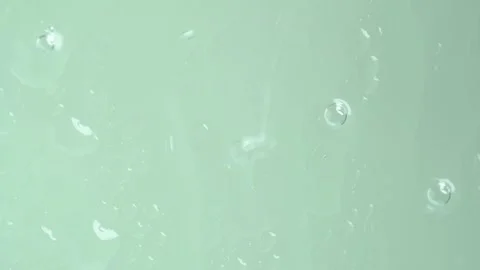 Rain falling on window surface. Water drops in window on light green backgr.. Stock Footage 269134992