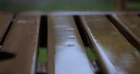 Rain falling on wooden planks. macro view of rain falling on a wooden table Stock Footage 337771466
