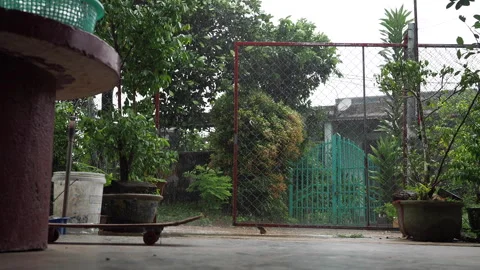 Rain falling in the yard of a house in southeast asia, view on the outdated Stockbeeldmateriaal 274074747