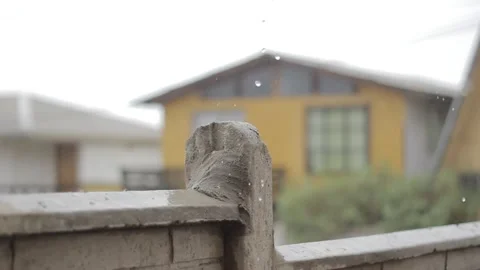 Rain falling with a yellow house in the background Stock Footage 233382309