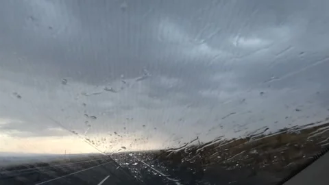 Rain falls across a highway in front windshield view Stock Footage 343805253