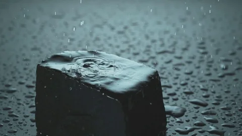 Rain falls on a black Stone Stock Footage 84079020