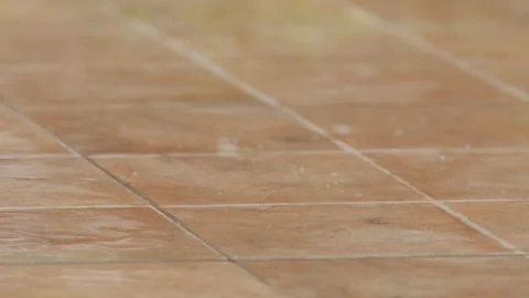 Rain falls on the brown tile floor. Видео 308438127