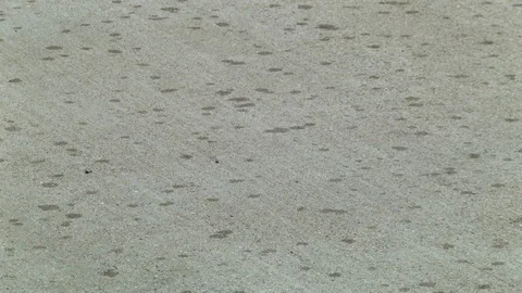 Rain falls on dry pavement Stock Footage 95857013