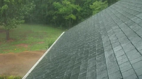 Rain falls heavily on the rooftops from passing storm.Macro Video Slow Motion. Stockbeeldmateriaal 336571230