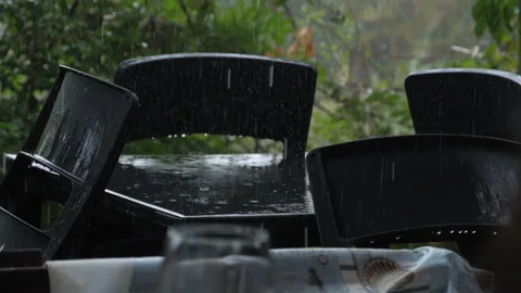 Rain falls over a table and chairs 動画素材 294206434