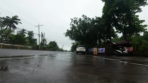 Rain falls on a slick road under overcast skies. Vídeos de archivo 334627818