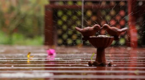 Rain falls on stone bird bath on beautiful wooden deck Stock Footage 45733533