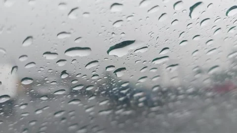 Rain falls on a window as people move around a busy street in the city during a Video stock 326374301