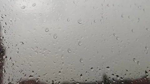 Rain falls on a window while clouds cover a city on a gray day Stock Footage 340462012