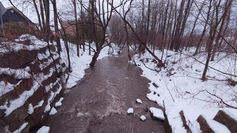 Rain fed river flowing through snowy forest Stock Footage 324547928