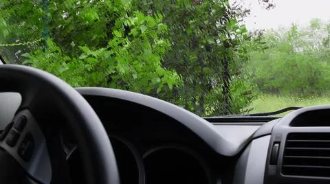 Rain flow pour through transparent windshield with defocused background of green Stock-Fotos