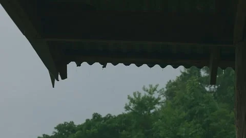 Rain flowing down from the eaves of the hut. Stock Footage 271372356