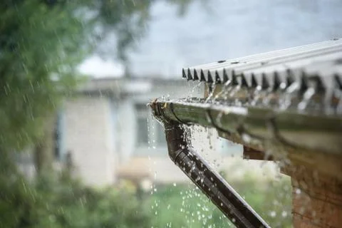 Rain flows down from a roof down Stock Photos