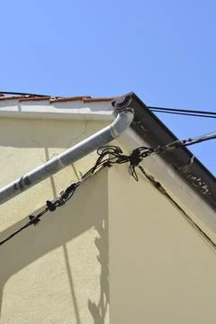 Rain gutter and cables on a house corner Stock Photos