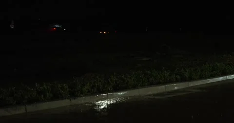Rain in gutter with flashing lights in background Stock Footage 277388070