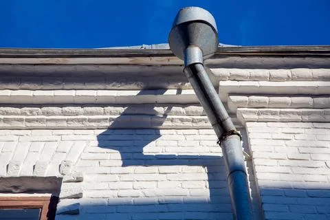 A rain gutter of a galvanized storm downspout pipe. Stock Photos