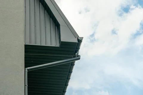 Rain Gutter Installation on a Building Under a Partly Cloudy Sky With a Cle.. Stock Photos