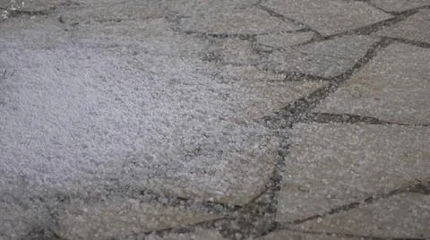 Rain with hail falling on the tailed sidewalk. Stock Photos
