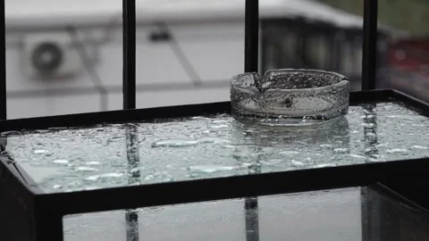 Rain Hitting Glass Table and Ashtray Stock Footage 241021119