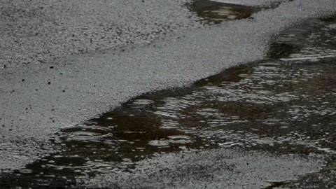 Rain hitting a street with puddles Stock Footage 132818245