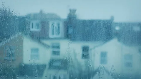 Rain Hitting Window With Houses Out Of Focus Behind Stock Footage 181127299
