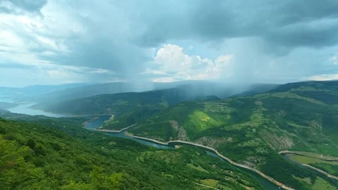 Rain lashes over emerald hills and winding lake. Kozji Kamen viewpoint, Serbia 스톡 동영상 341875496