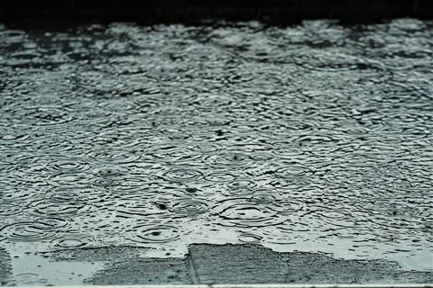 Rain is makes circles on a black flat roof Stock Photos