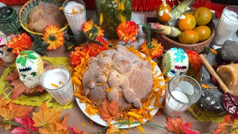 Rain of marigold petals fall on pan de muerto in day of death offering Stock Footage 292348849