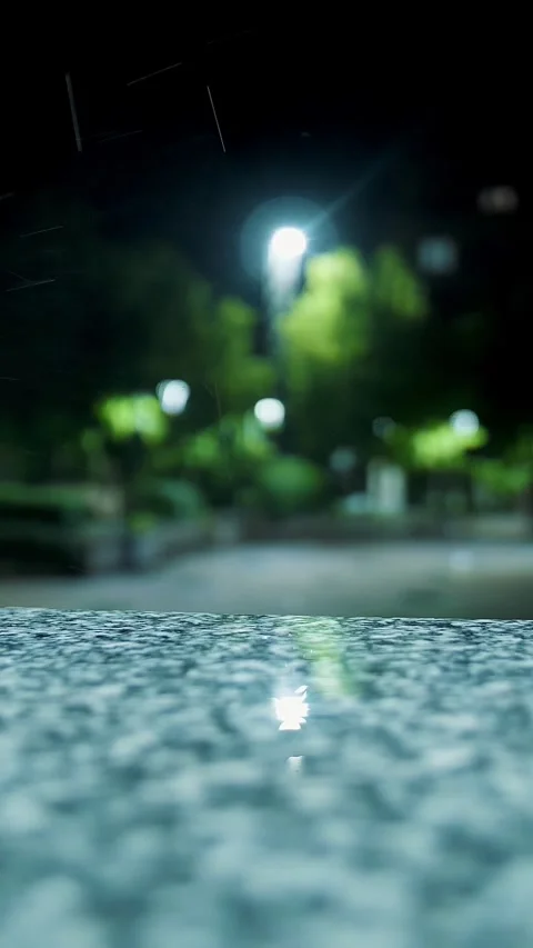 Rain in the night. Puddle. Streetlight. Rain drops Falling On puddle. Close-up. Stock Footage 311994976