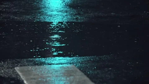 Rain at night - raindrops on the road reflected in traffic lights Stock Footage 257890271