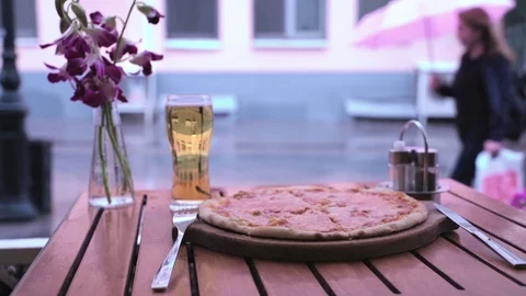 Rain outside the window of the cafe. A glass of beer and pizza. Abstract Vídeo Stock 78049116
