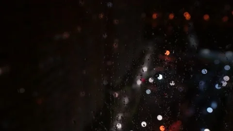 Rain outside the window, drops dripping on the glass, night city in the rain Stock Footage 197442503