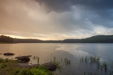 Rain over the lake at sunset Stock Photos