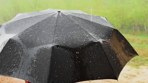 The rain is pouring, the drops fall on a black umbrella, flowing down from it Stock Footage 91055781