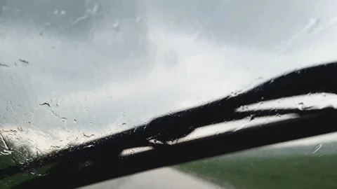 The rain is pouring on the windshield of a moving car. Stock Footage 156950042