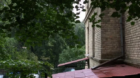 Rain pouring in the yard of brick building in summer in Vilnius Stock Footage 249073552